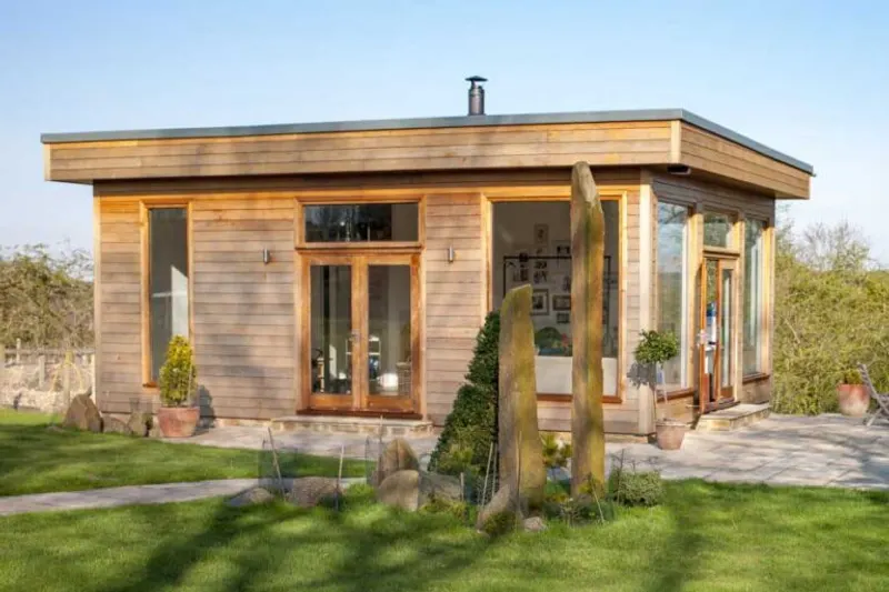 Timber-clad garden room with large glazed doors set in a landscaped garden