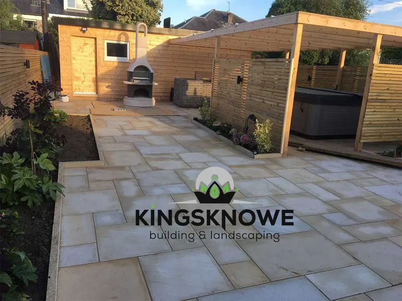 Hot tub set under a timber pergola on a paved patio in a landscaped Edinburgh garden